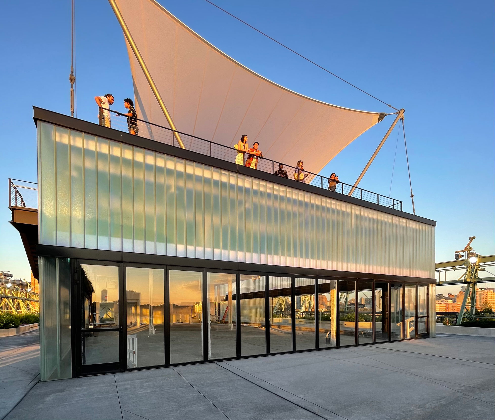 Channel glass facade at Pier 57 with people standing at the railing.