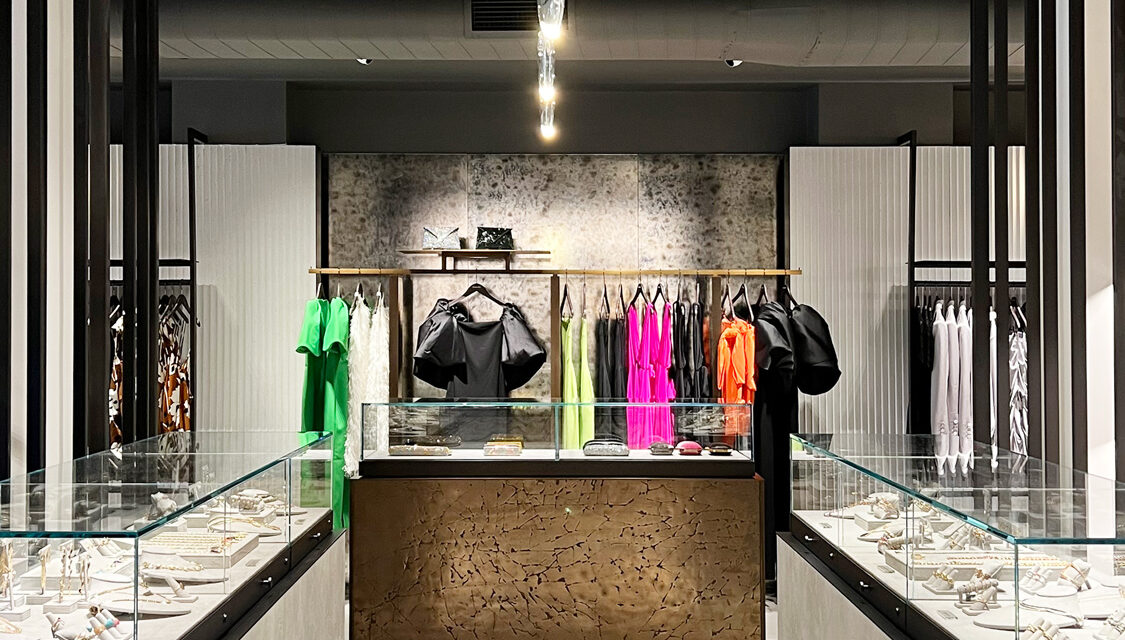 Antique mirror behind a clothing display.