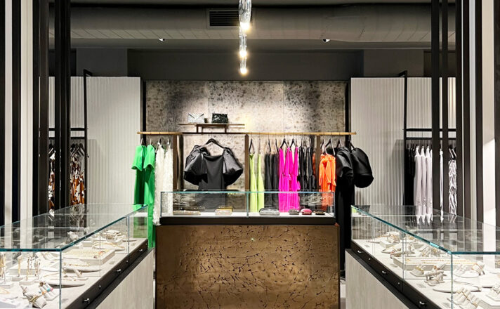 Antique mirror behind a clothing display.