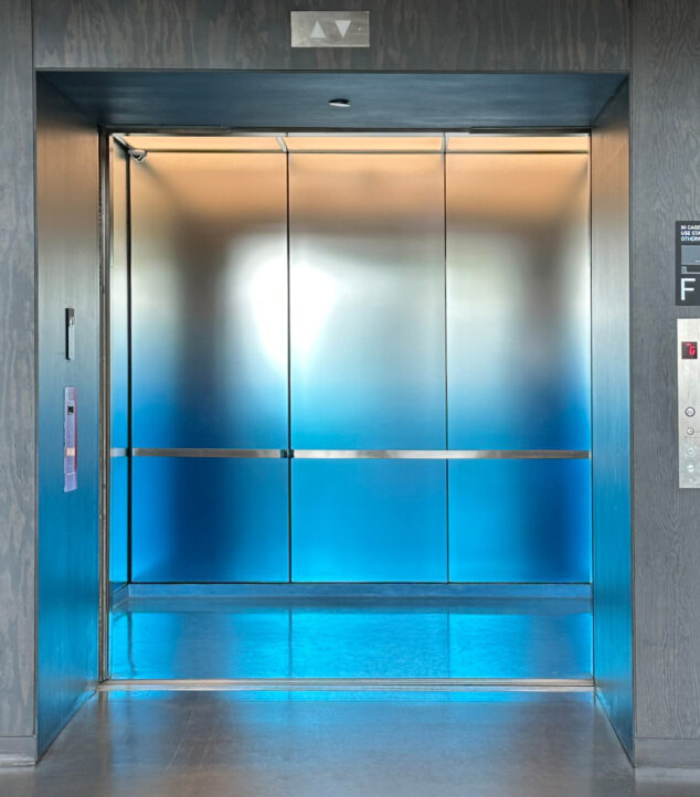 Elevator interior with glass walls.