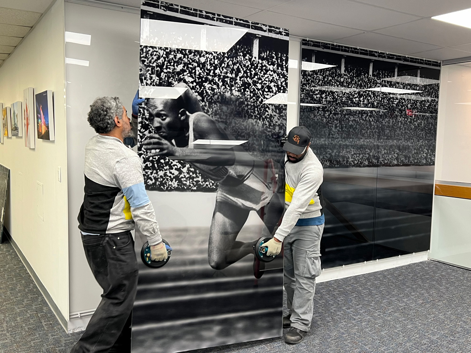 2 men installing glass panels into the wall