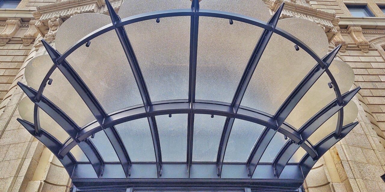 Textured glass creates a canopy above the building entrance.