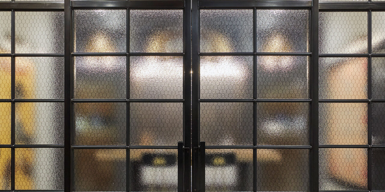 Wine room with doors and walls made of Bendhiem's chicken wire glass.
