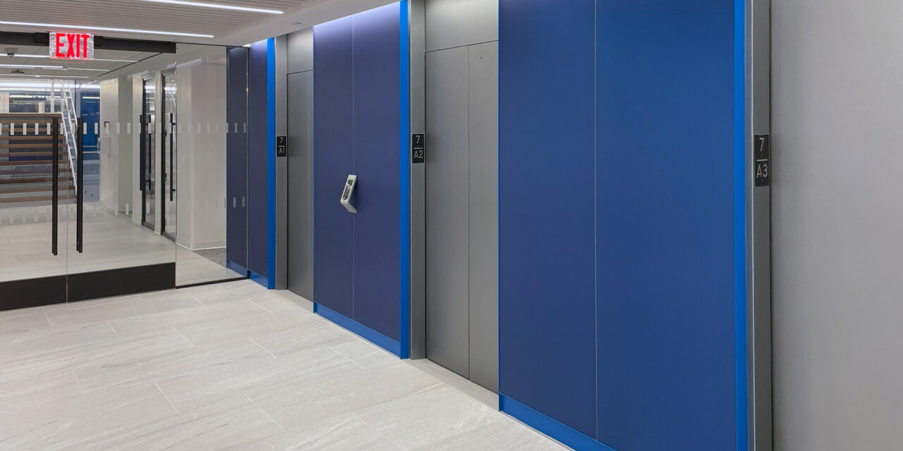 Blue etched glass cladding the walls of the elevator lobby.