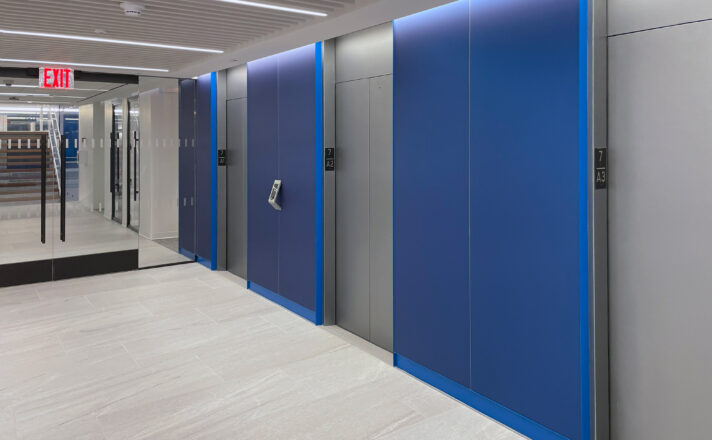 Blue etched glass cladding the walls of the elevator lobby.