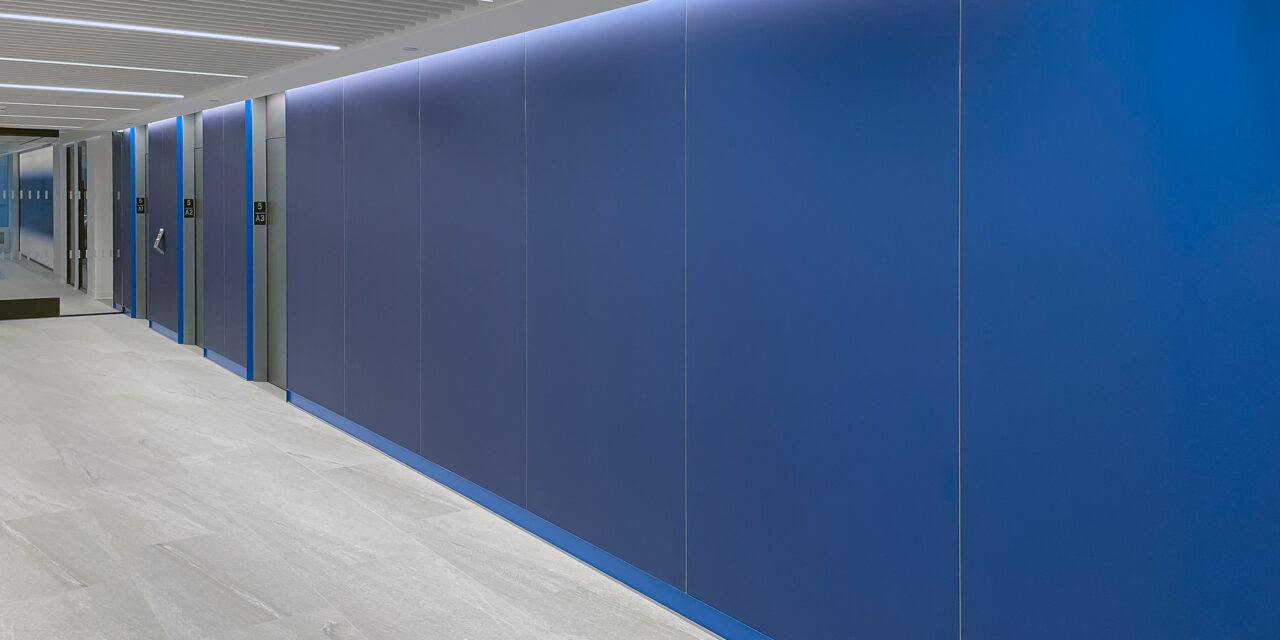 Blue etched glass cladding the walls of the elevator lobby.