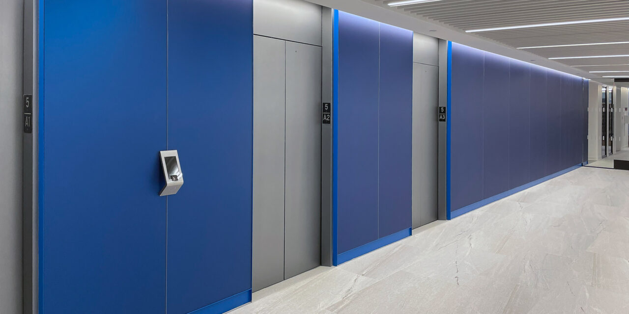 Blue etched glass cladding the walls of the elevator lobby.