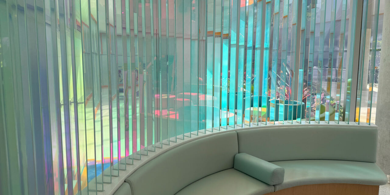 Dichroic glass fins creating a wall in a seating area.