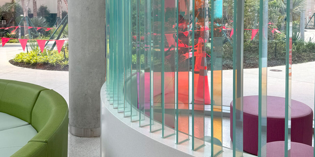 Dichroic glass fins creating a wall in a seating area.