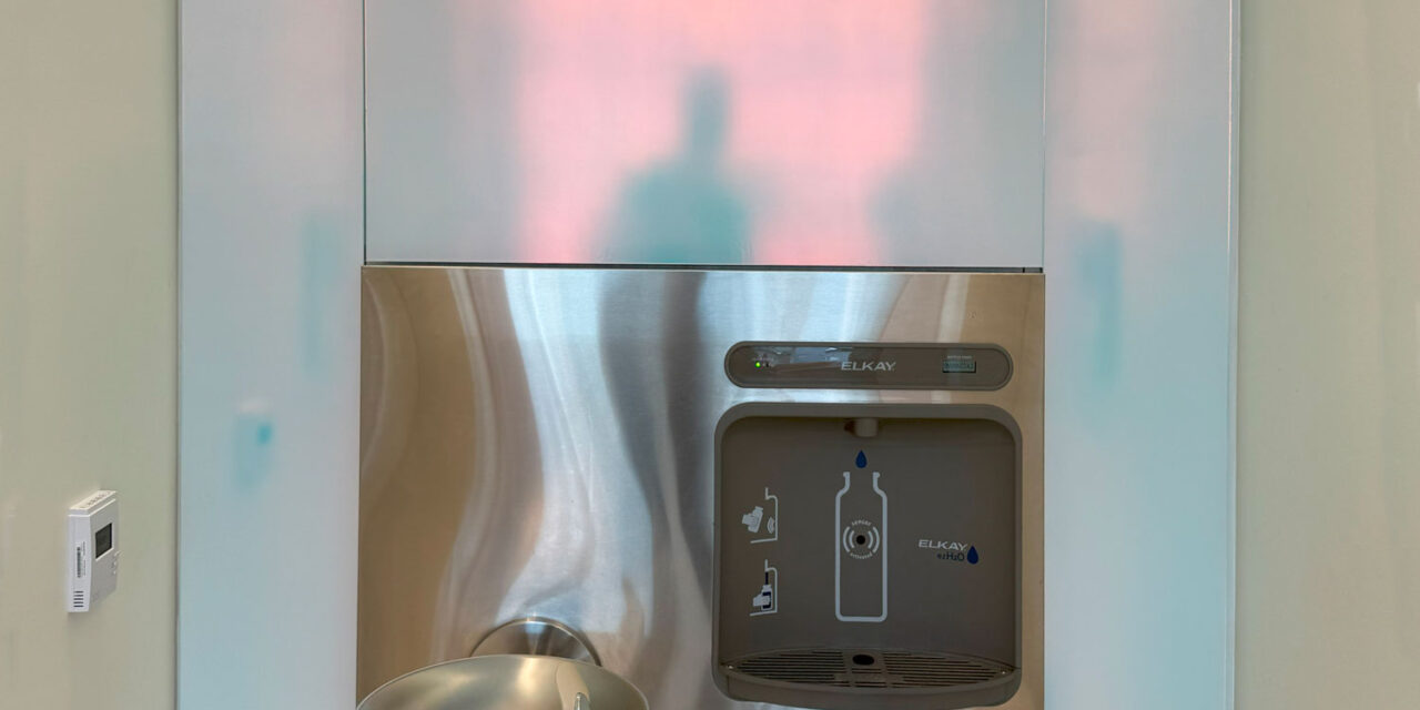 Etched dichroic glass clads the walls around the water fountains.