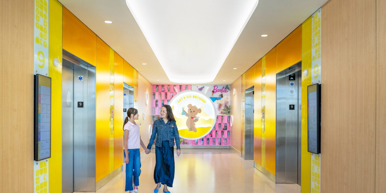 Elevator lobby walls made of colorful Bendheim glass with a child and mother leaving the elevator.