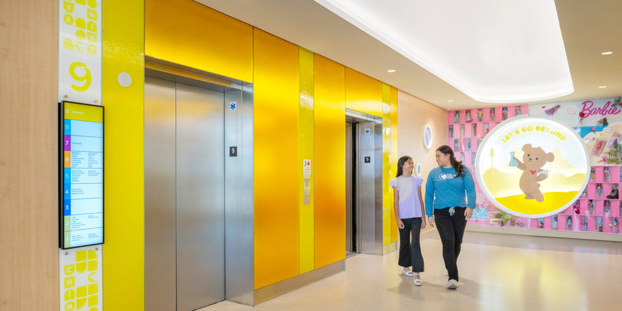 Elevator lobby walls made of colorful Bendheim glass with a child and mother leaving the elevator.