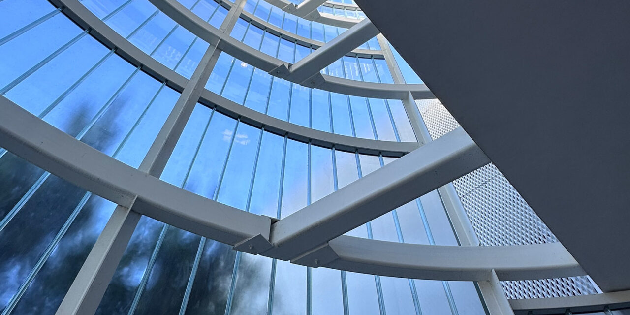 Interior view of the curved channel glass wall by Bendheim over the exterior elevator lobby.