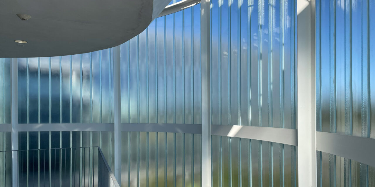 Interior view of the curved channel glass wall by Bendheim over the exterior elevator lobby.
