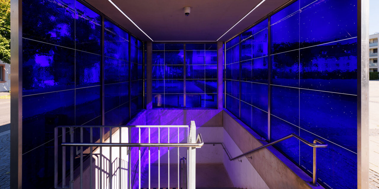 Blue mouth-blown glass enclosing a stairwell.
