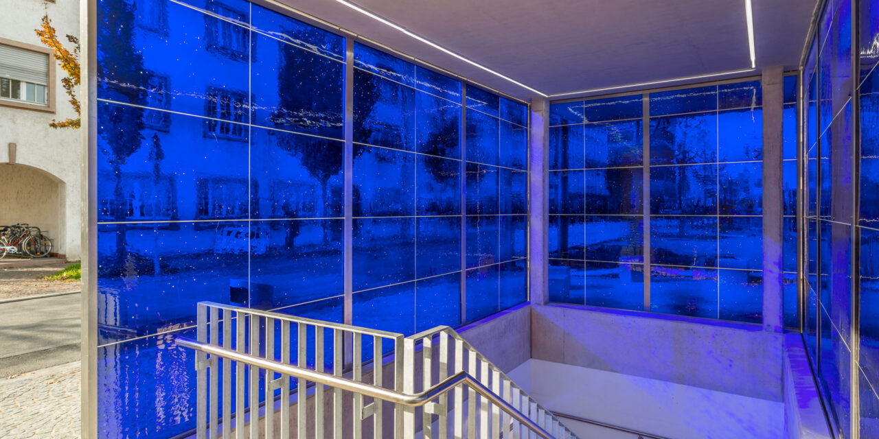 Blue mouth-blown glass enclosing a stairwell.