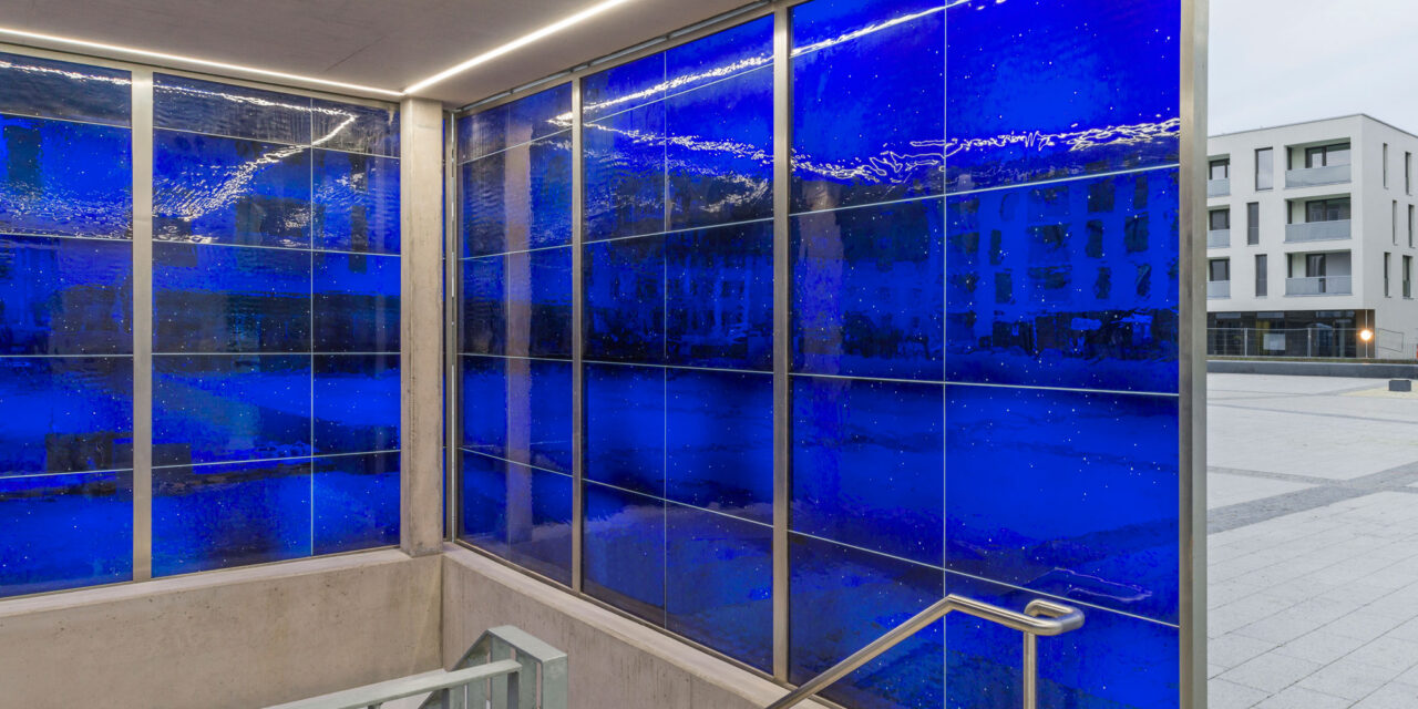 Blue mouth-blown glass enclosing a stairwell.