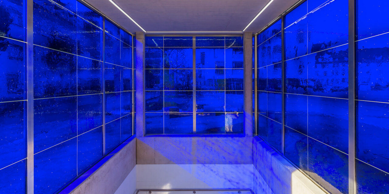Blue mouth-blown glass enclosing a stairwell.